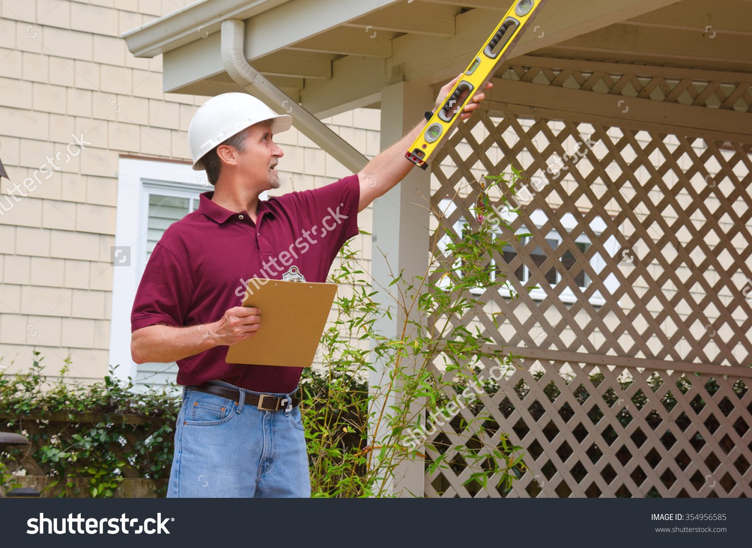 stock-photo-a-home-inspector-or-house-building-repair-contractor-in-a-hard-hat-holding-a-level-and-a-clipboard-354956585